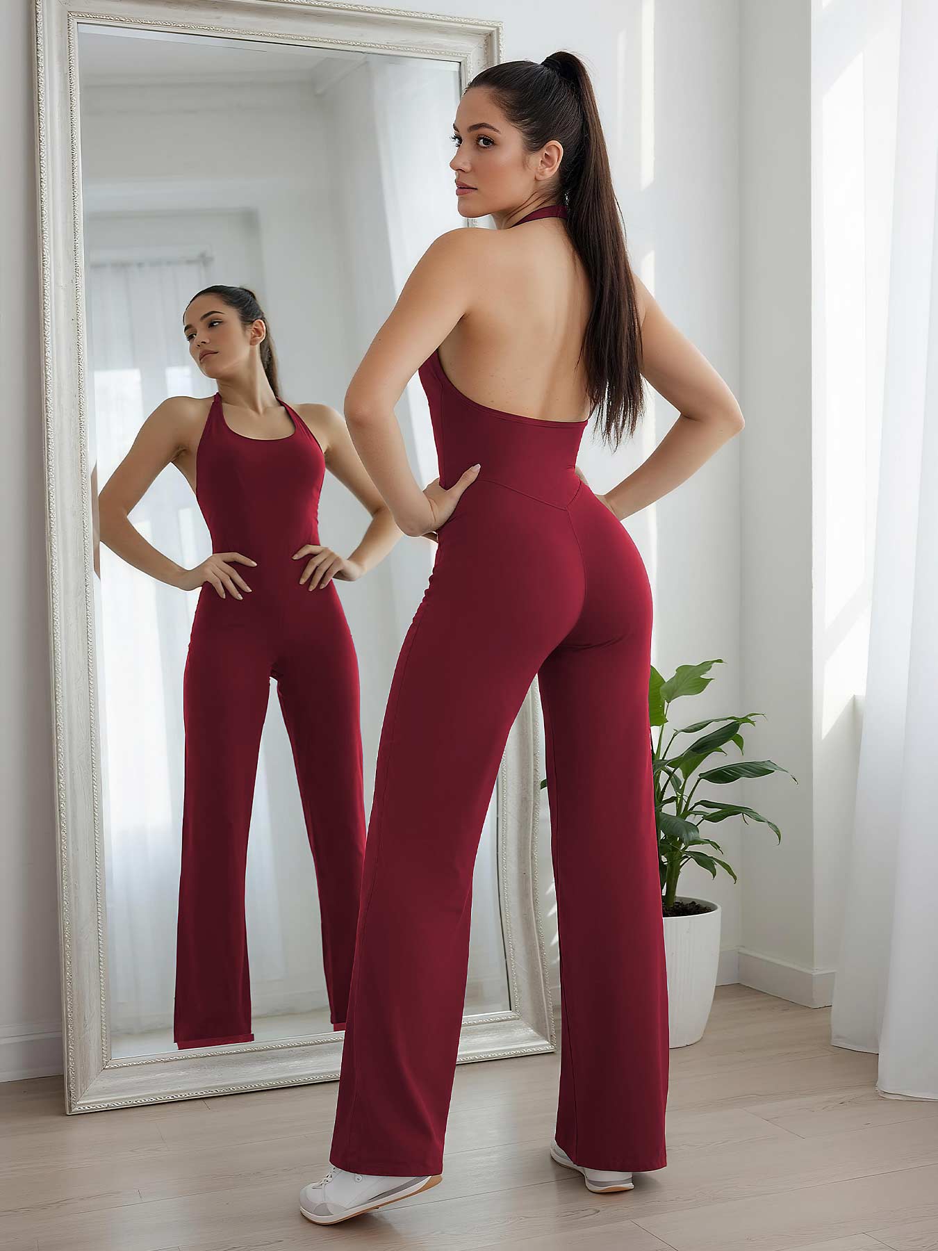 Mirror pose—model showing curves in anchor red straight-leg halter jumpsuit