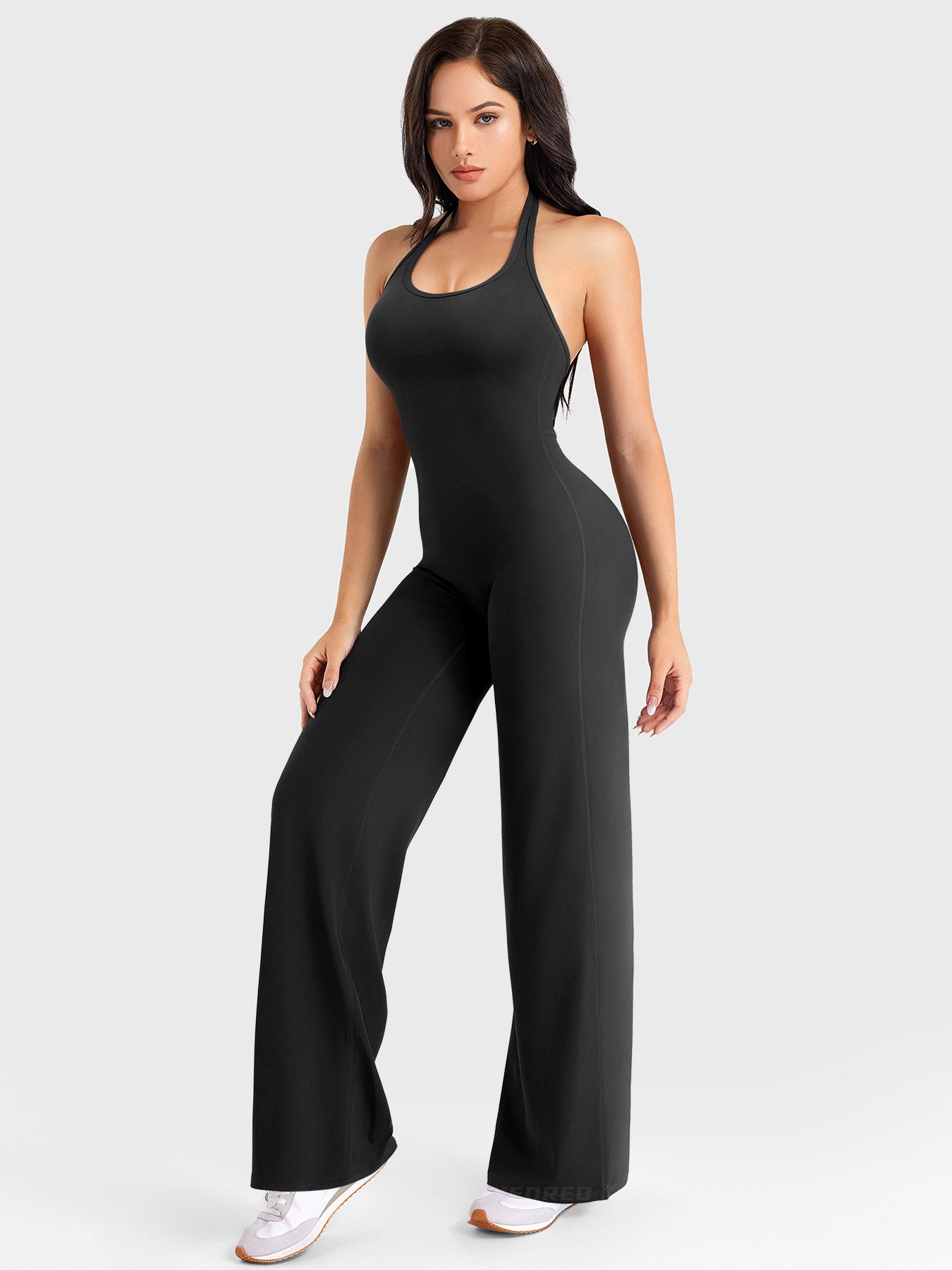 Side-front stretch pose wearing black halter straight-leg jumpsuit