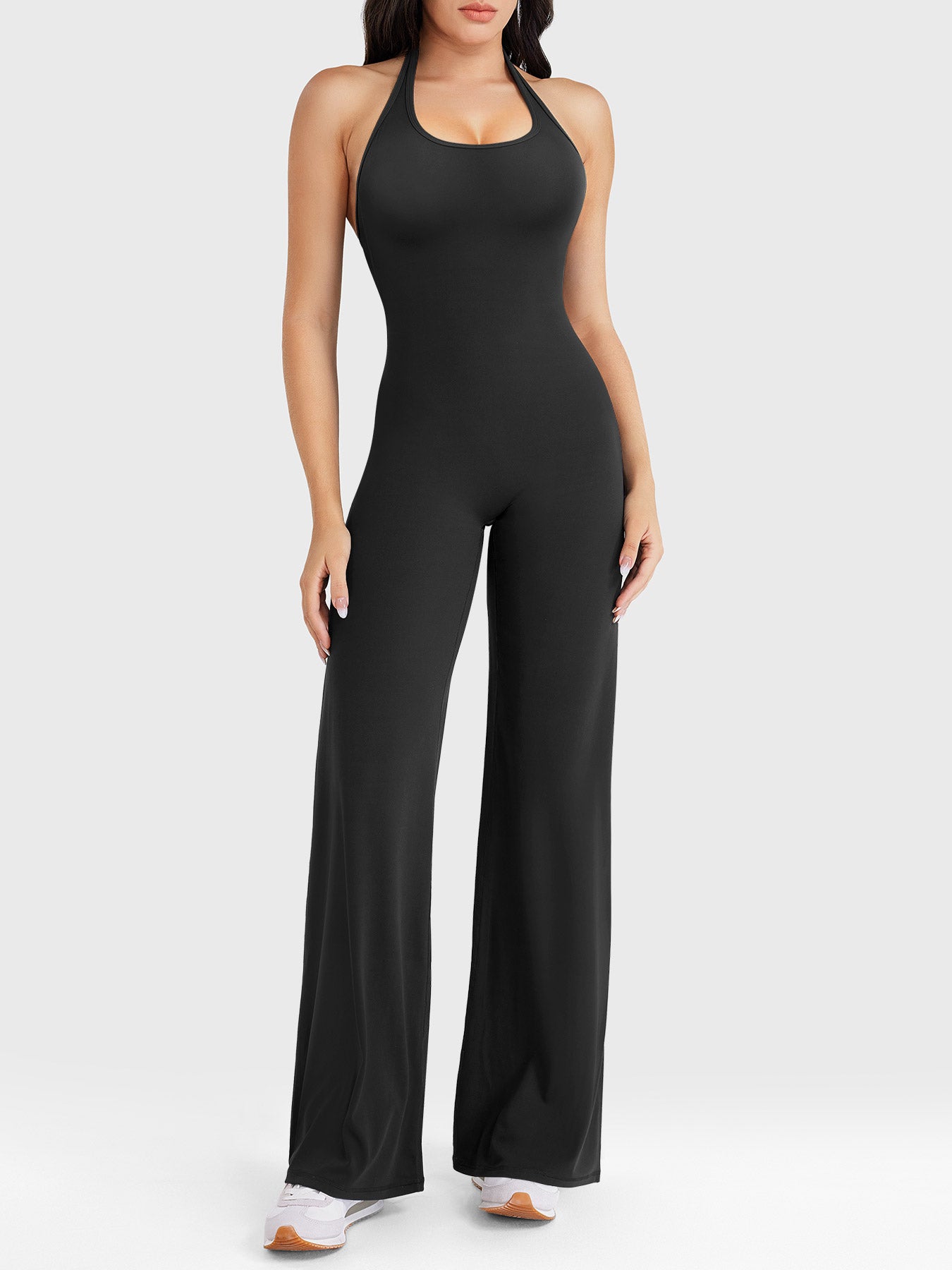 Front view—model wearing black halter open-back straight-leg jumpsuit