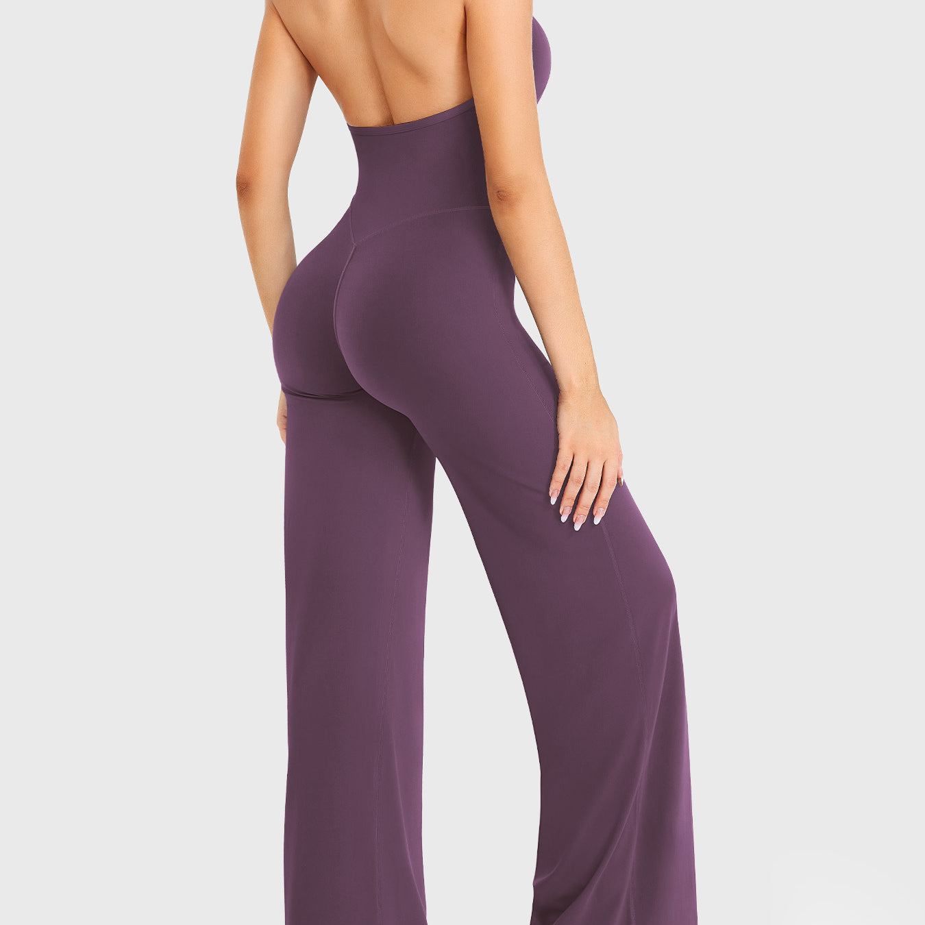 Side-front stretch pose wearing black berry halter straight-leg jumpsuit