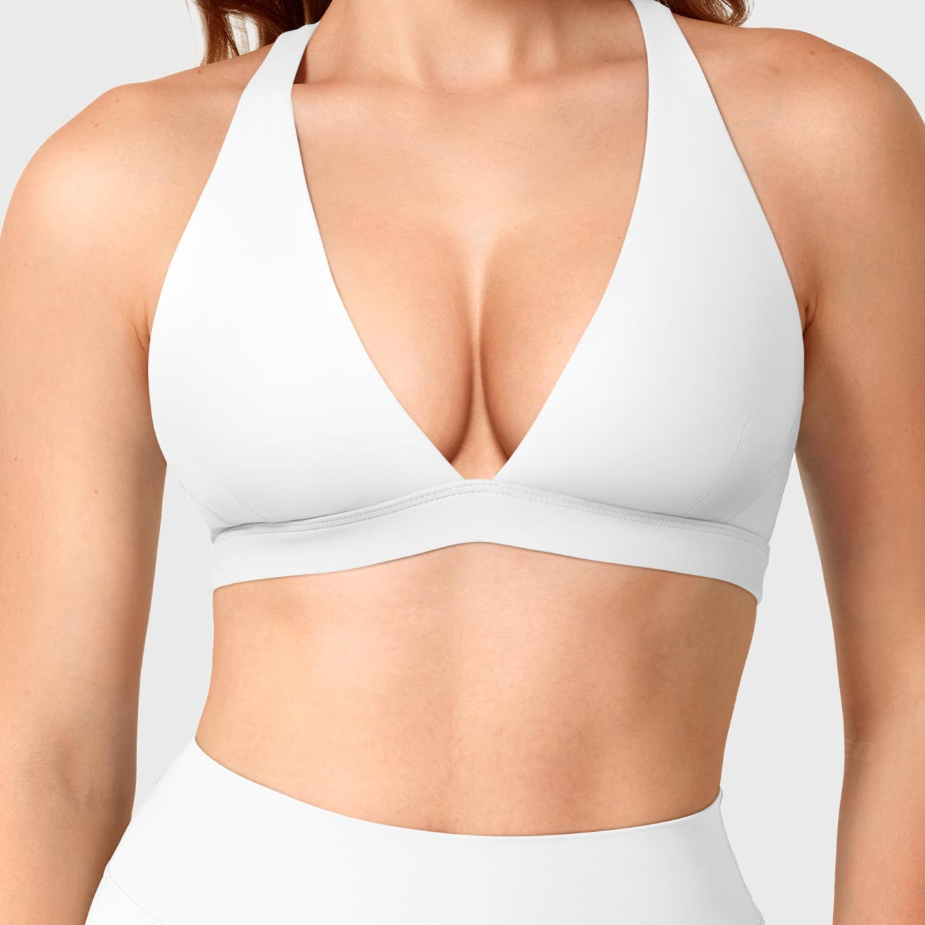 White Yeoreo Wafiya cross back sports bra front view, plunge V-neck shaping collarbone with elastic support band