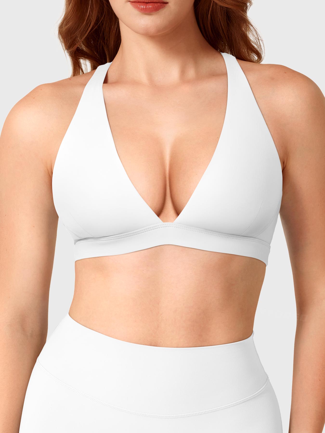 White Yeoreo Wafiya cross back sports bra front view, plunge V-neck shaping collarbone with elastic support band