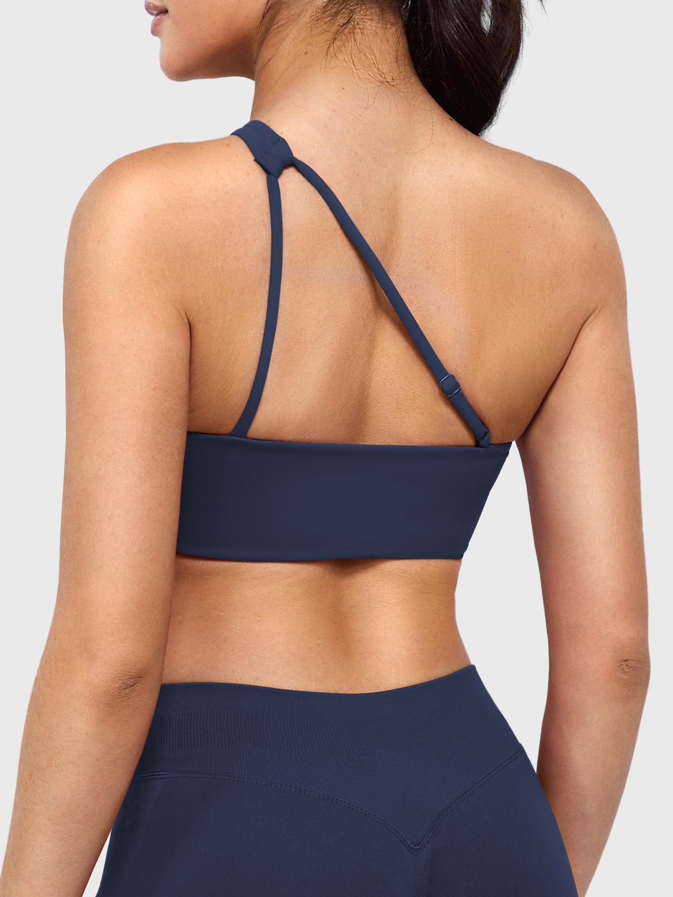 Claranie One Shoulder Sports Bra in navy, angled back view upper body, open back with adjustable strap, clean and breathable design