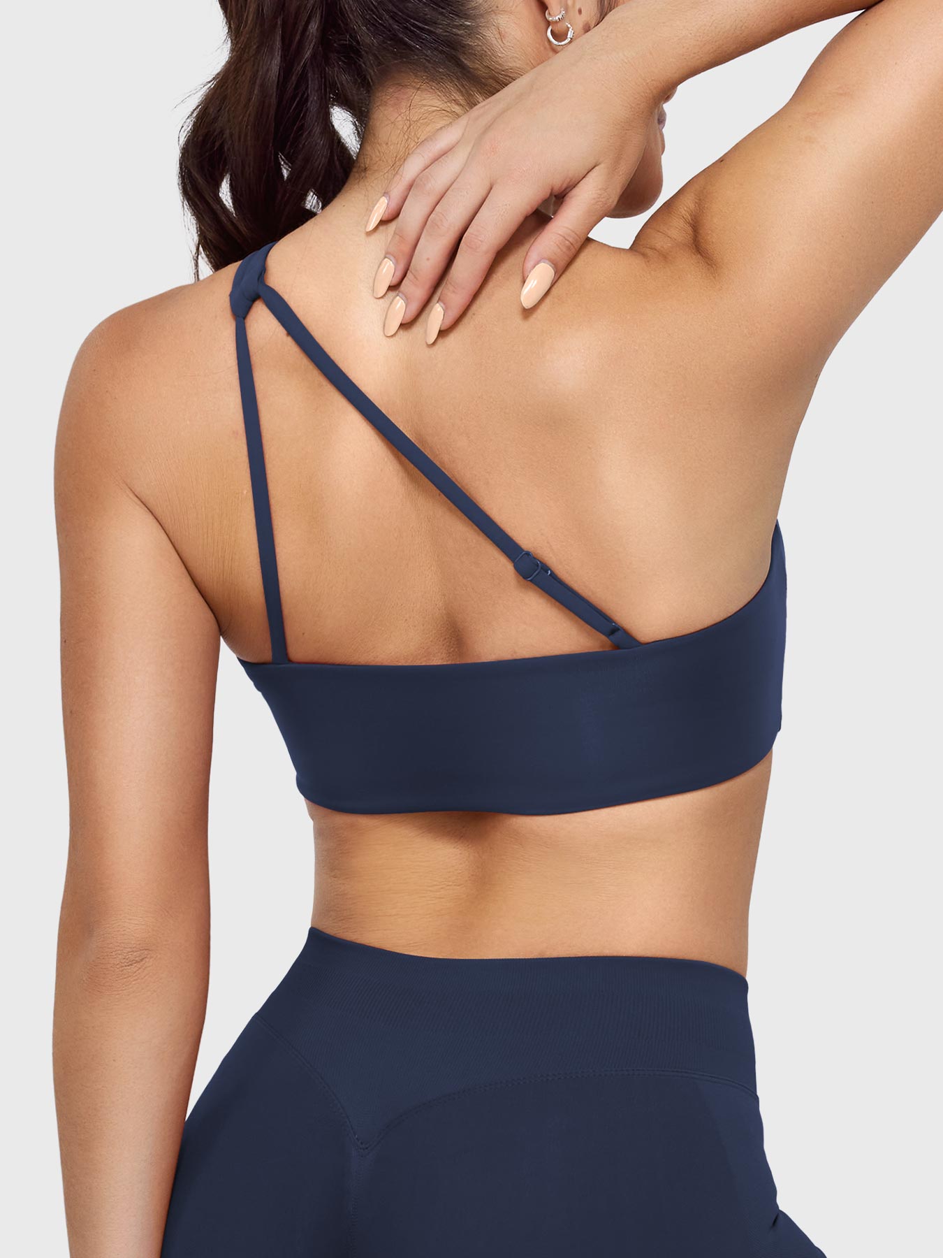 Claranie One Shoulder Sports Bra in navy, angled back upper body view, supportive side coverage, elegant open back silhouette