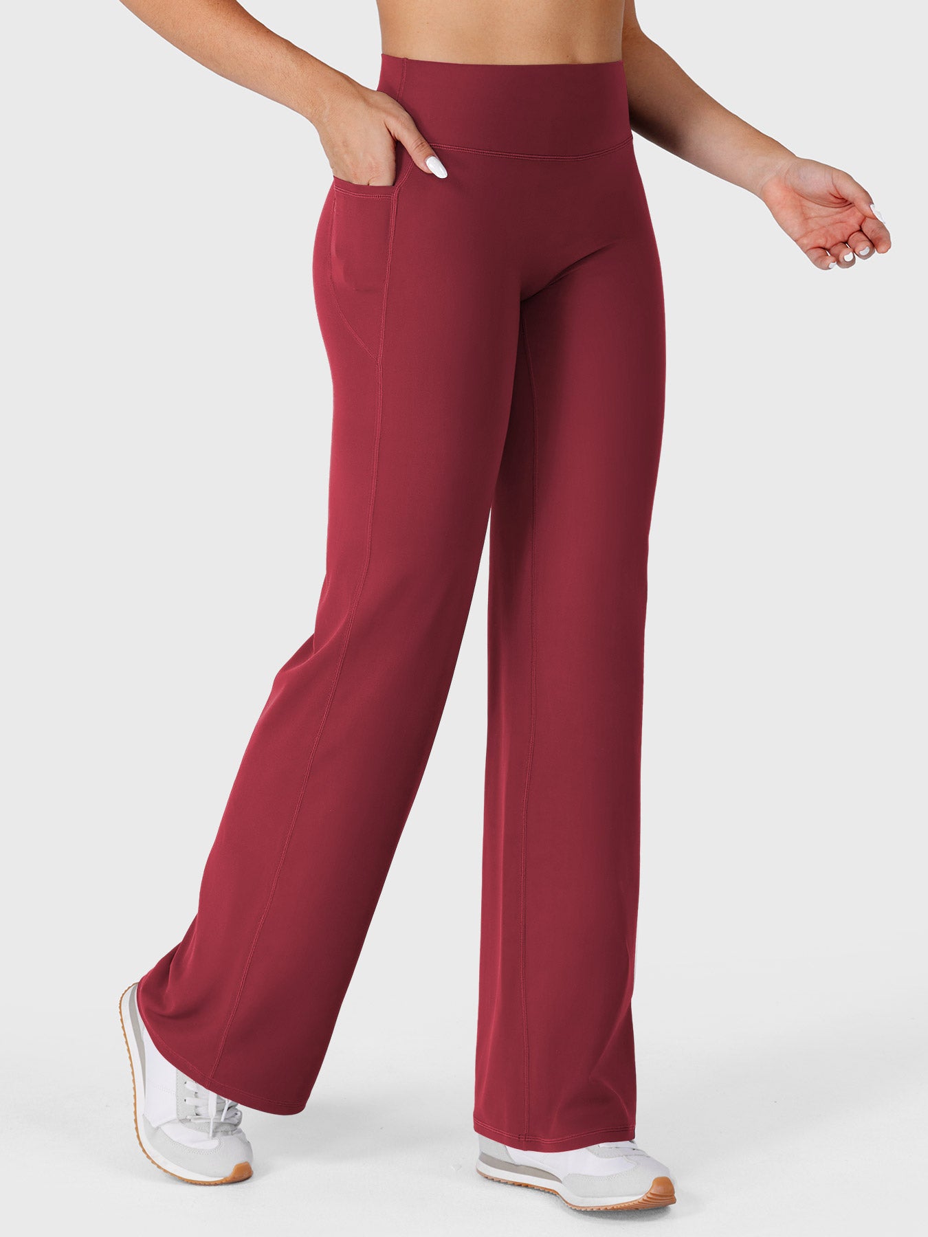 Ancora red straight leg leggings with pockets walking front angle, hands in pockets