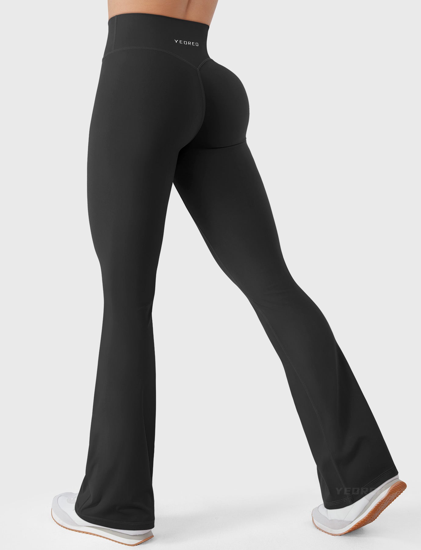 Black bootcut mini flare leggings with V-back and hidden scrunch, side-back walking pose