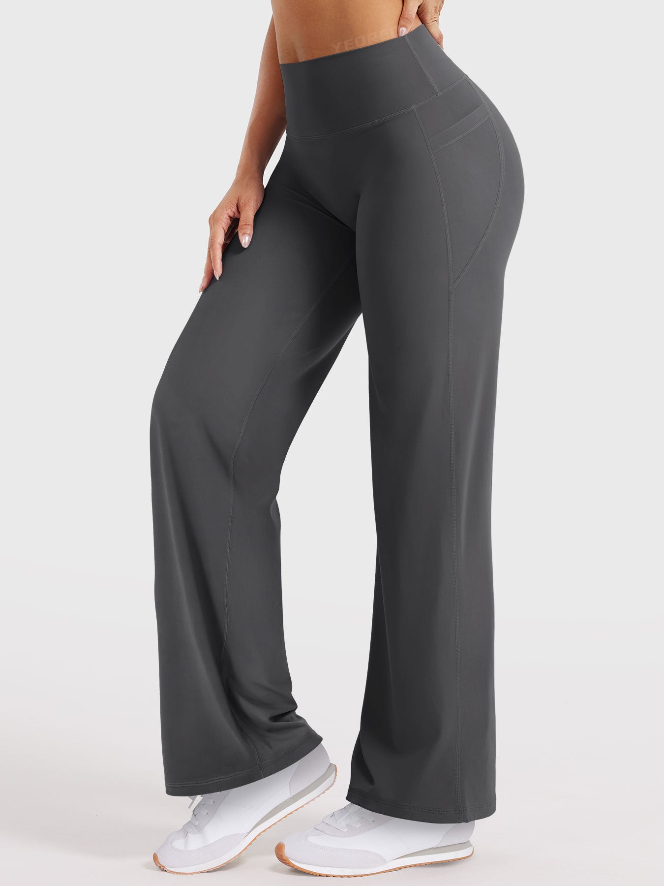 Side-front pose wearing dark grey straight leg leggings with pockets, relaxed athleisure fit