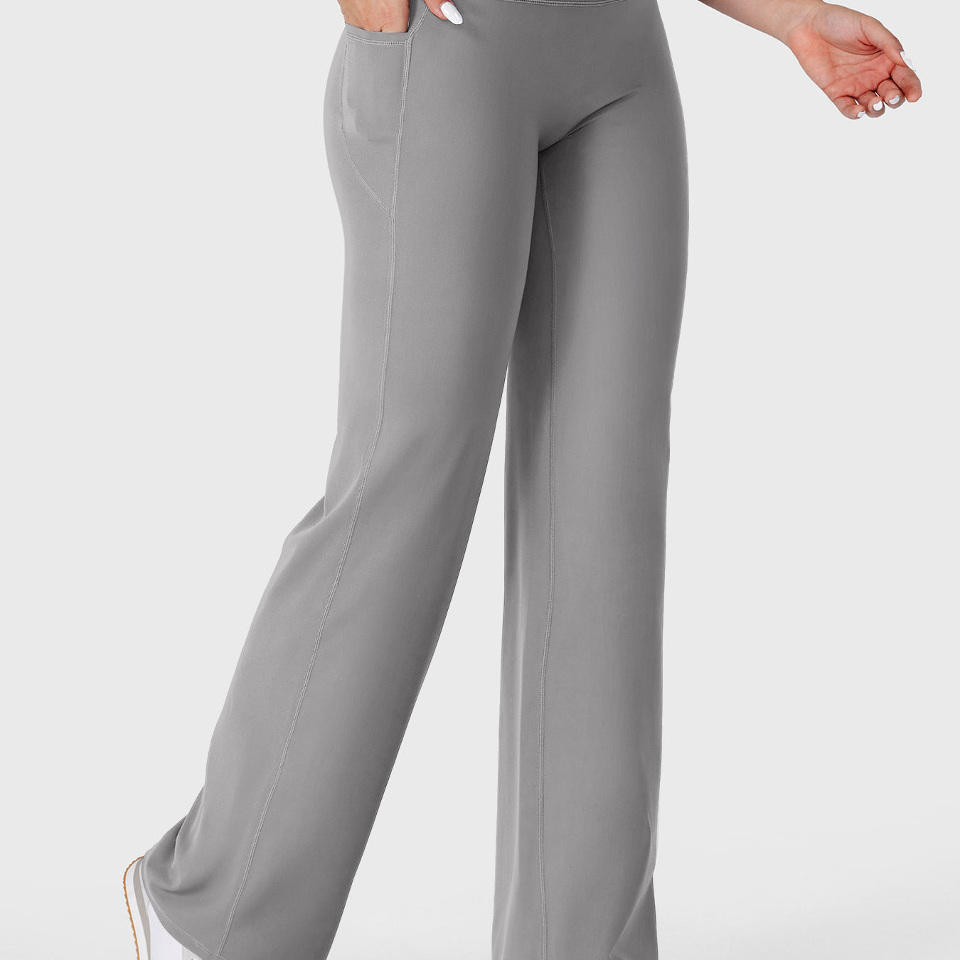 Light grey straight leg leggings with pockets walking front angle, hands in pockets