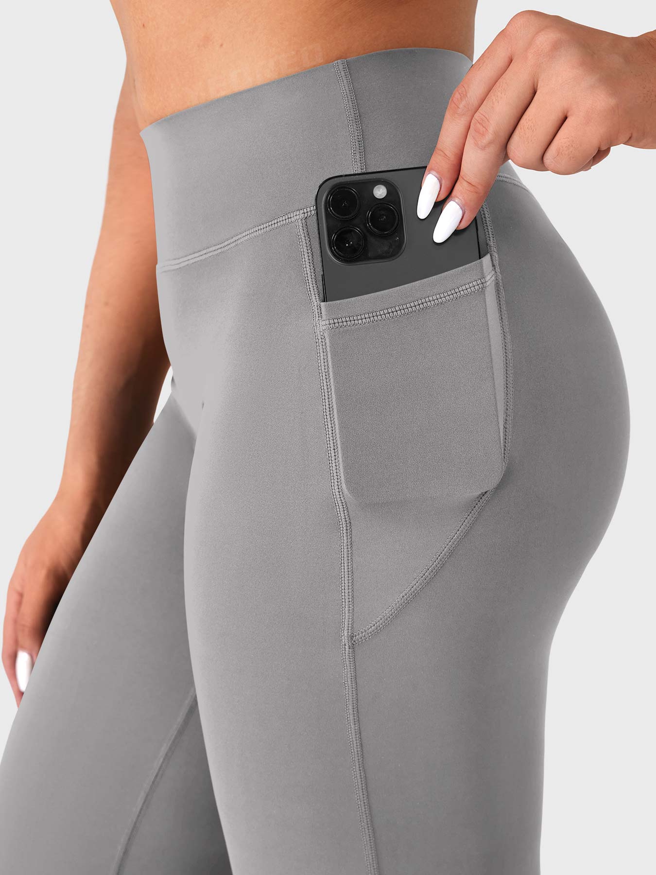 Light grey straight leg leggings side pocket close up with phone, functional workout pants