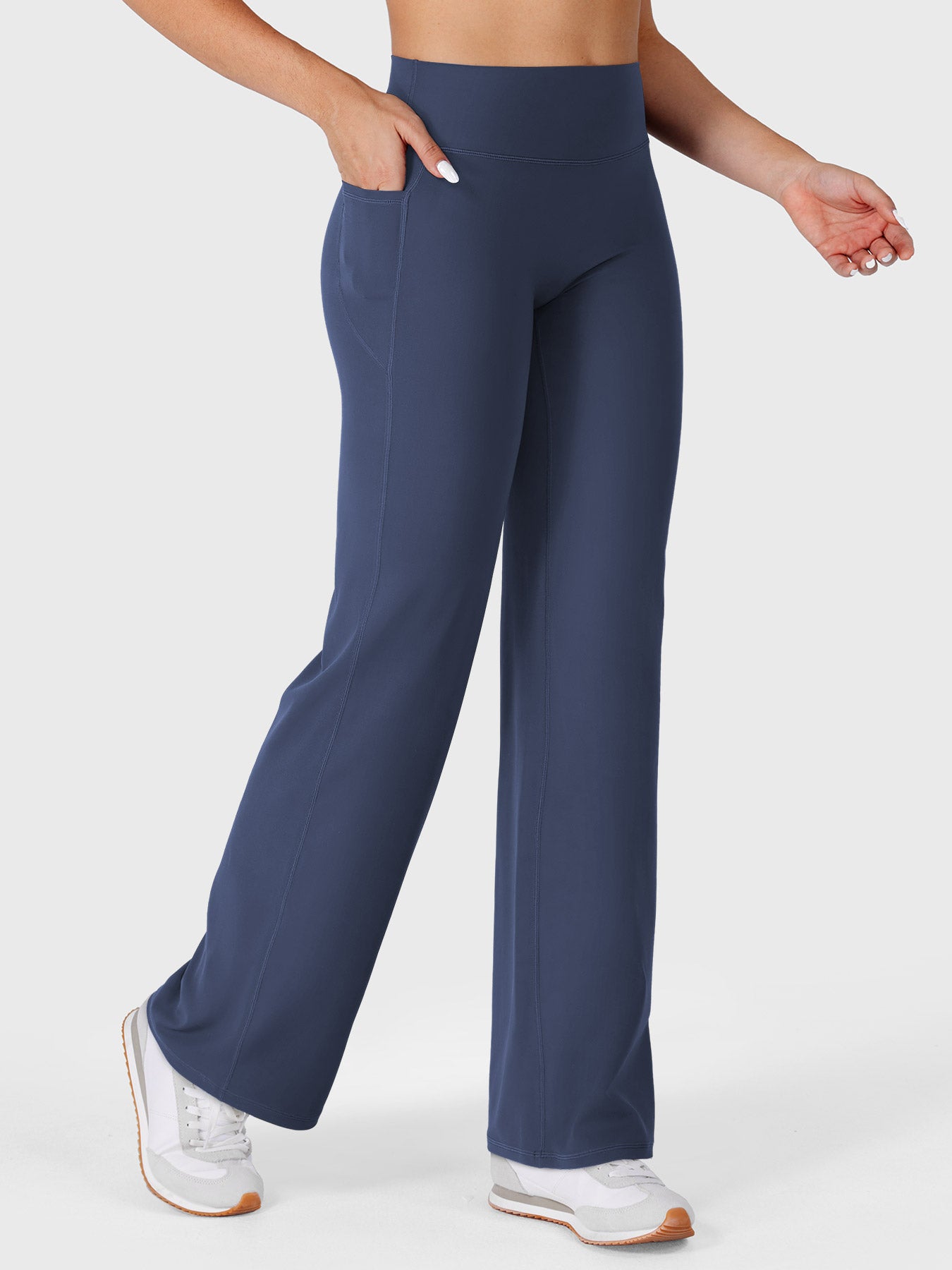 Navy straight leg leggings with pockets walking front angle, hands in pockets casual athleisure style