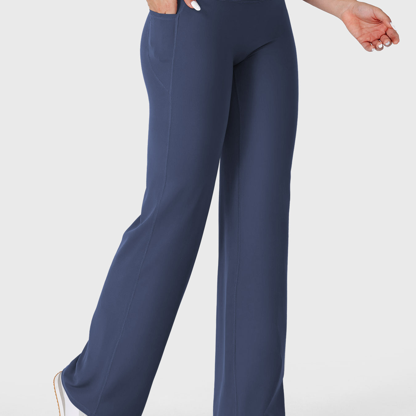 Navy straight leg leggings with pockets walking front angle, hands in pockets casual athleisure style