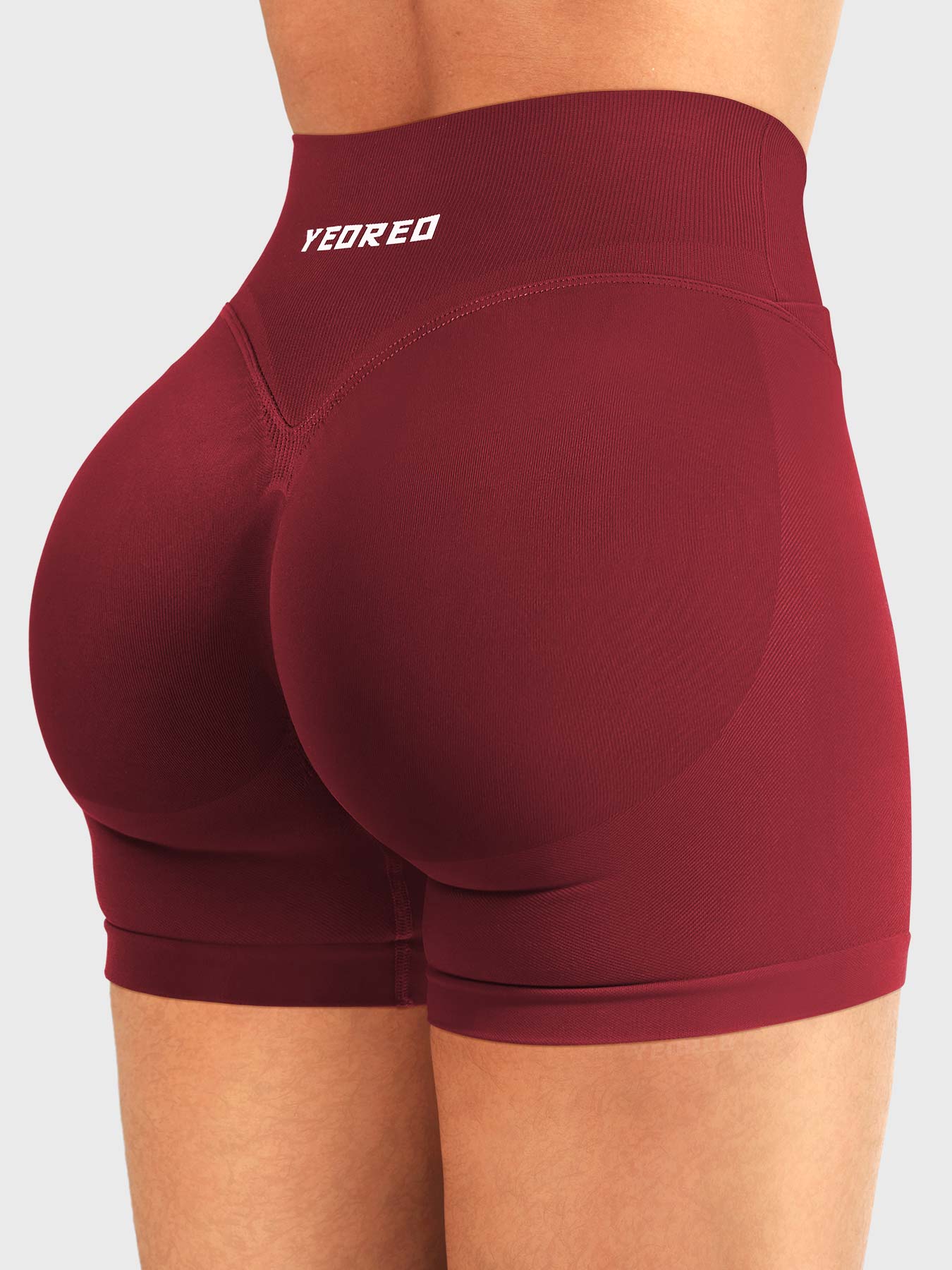Scarlett Red Baderiy 4.5" V-waist seamless shorts angled back view, smooth seamless structure enhancing curves
