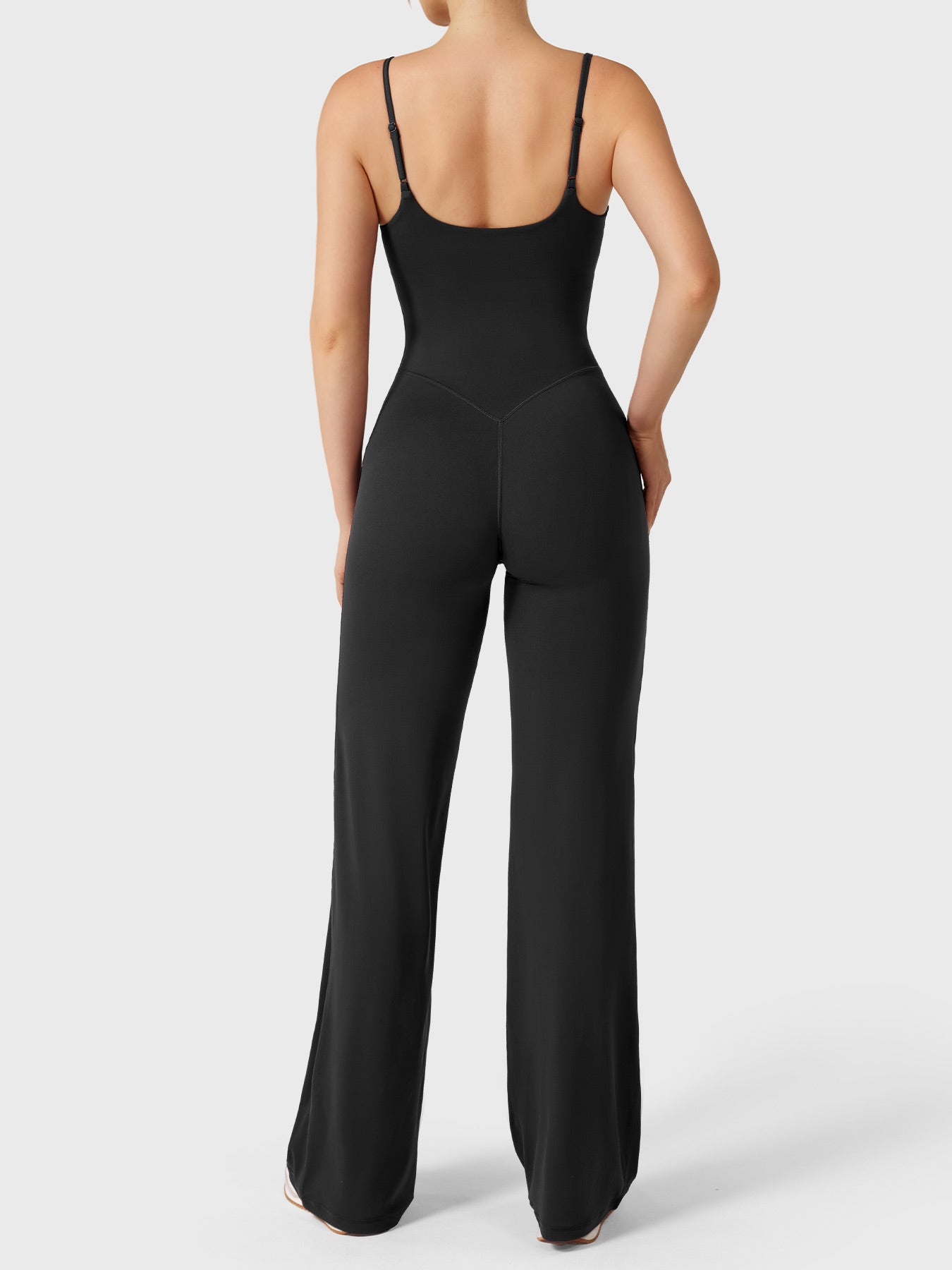 Dagyane Straight Leg Jumpsuit in black, back view model pose, open back design, adjustable shoulder straps, V-back detail shaping glutes