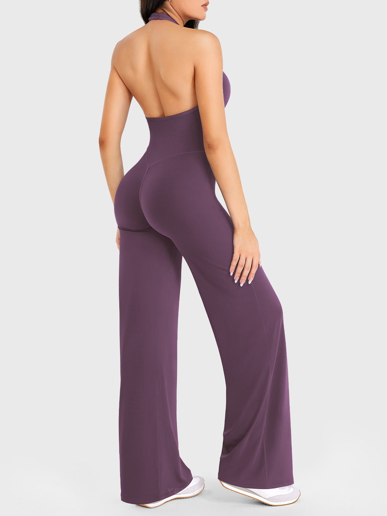 Side-front stretch pose wearing black berry halter straight-leg jumpsuit