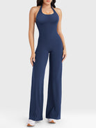 Front view—model wearing navy halter open-back straight-leg jumpsuit