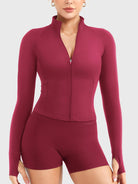 Candecy Full Zip Workout Jacket in ruby red, front view standing, partially unzipped V neckline, princess seams, hidden zip pockets, thumbhole sleeves