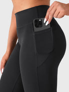 Close-up of black straight leg leggings side pocket with phone, practical athleisure design