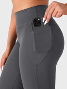 Close-up of dark grey straight leg leggings side pocket holding phone, functional design