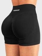 Black Baderiy 4.5" V-waist seamless shorts angled back view, seamless compression supporting a flattering fit