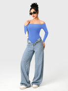Dacrly Off Shoulder Bodysuit in blue, full body front view layered with jeans, styled with sunglasses and mini shoulder bag, Y2K outfit